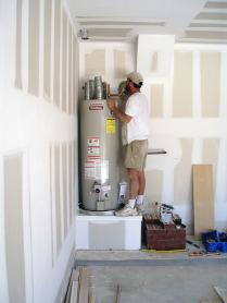 Irving TX plumber installing a new water heater in a garage