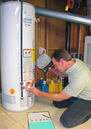 Irving plumber inspects the electronics on a GE water heater